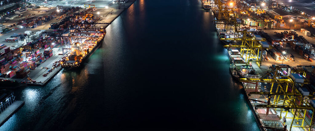 aerial view of harbor canal night with container cranes on one side