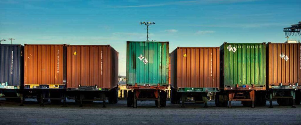 Different colored cargo containers on trailers